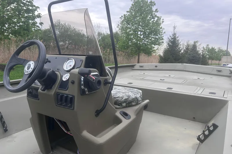Slide: The Image of 2024 Tracker Grizzly 2072 CC boat interior with steering console and seating. - 5