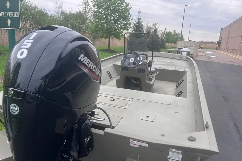 Slide: The Image of 2024 Tracker Grizzly 2072 CC boat with Mercury 150 engine, parked outdoors. - 9
