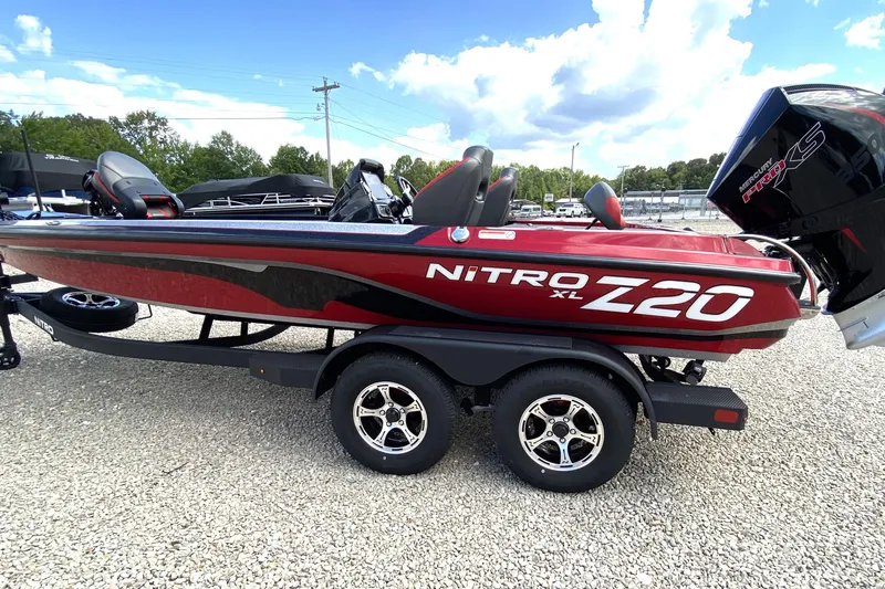 Slide: The Image of 2025 Nitro Z20 XL Pro boat with Mercury Pro XS engine, parked on gravel. - 0