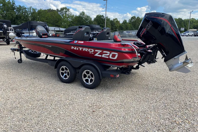 Slide: The Image of 2025 Nitro Z20 XL Pro boat with powerful engine, parked on gravel lot. - 2
