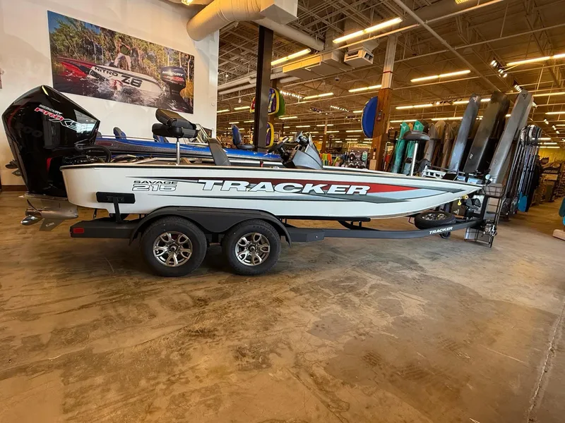 The Image of 2025 Tracker Savage 215 boat on trailer in showroom, featuring sleek design and modern features. - 0