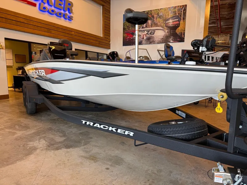 Slide: The Image of 2025 Tracker Savage 215 boat displayed indoors on a trailer. - 2