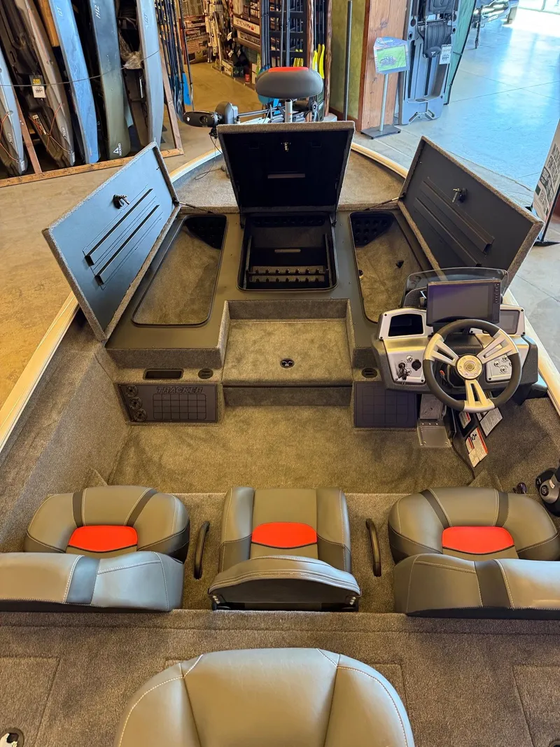 Slide: The Image of 2025 Tracker Savage 215 boat interior with seating, storage compartments, and steering console. - 4