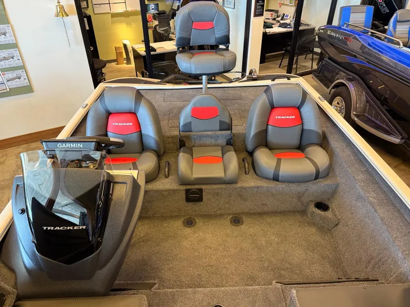 Slide: The Image of 2025 Tracker Savage 215 boat interior with gray and red seating, Garmin navigation system. - 7