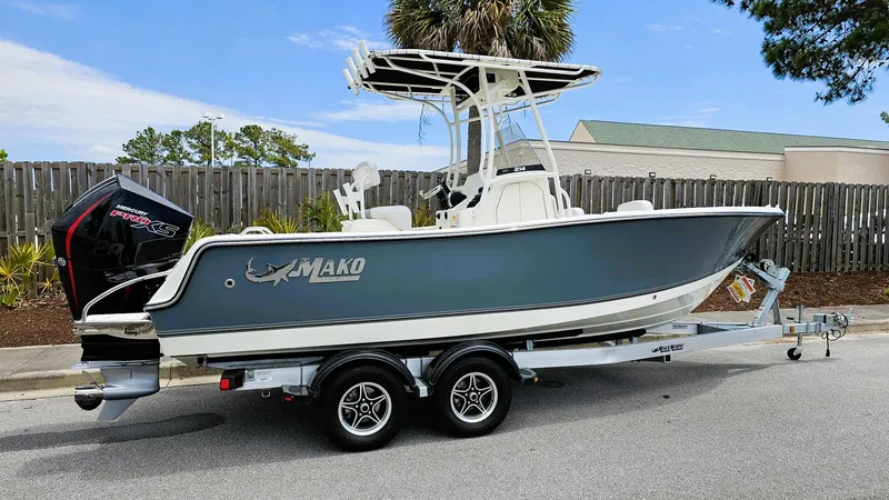 Slide: The Image of 2024 Mako 214 CC boat on trailer, parked outdoors, side view. - 1