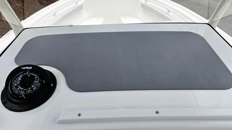 Slide: The Image of 2024 Mako 214 CC boat dashboard with compass and non-slip mat. - 10