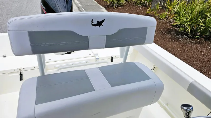 Slide: The Image of 2024 Mako 214 CC boat seating with shark logo, featuring gray and white upholstery. - 11