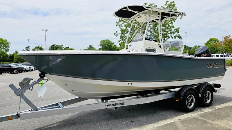 Slide: The Image of 2024 Mako 214 CC boat on trailer, parked outdoors, side view. - 3