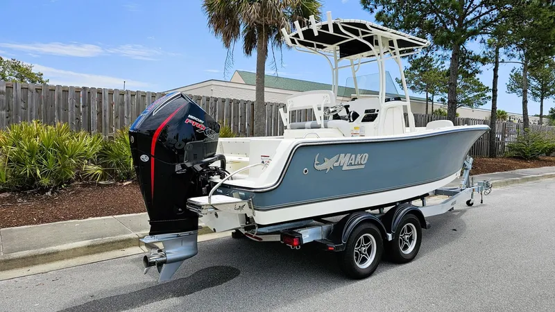Slide: The Image of 2024 Mako 214 CC boat on trailer, parked on street, with outboard motor. - 7