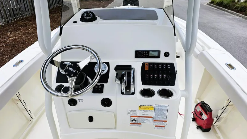 Slide: The Image of 2024 Mako 214 CC boat console with steering wheel and control panel. - 8