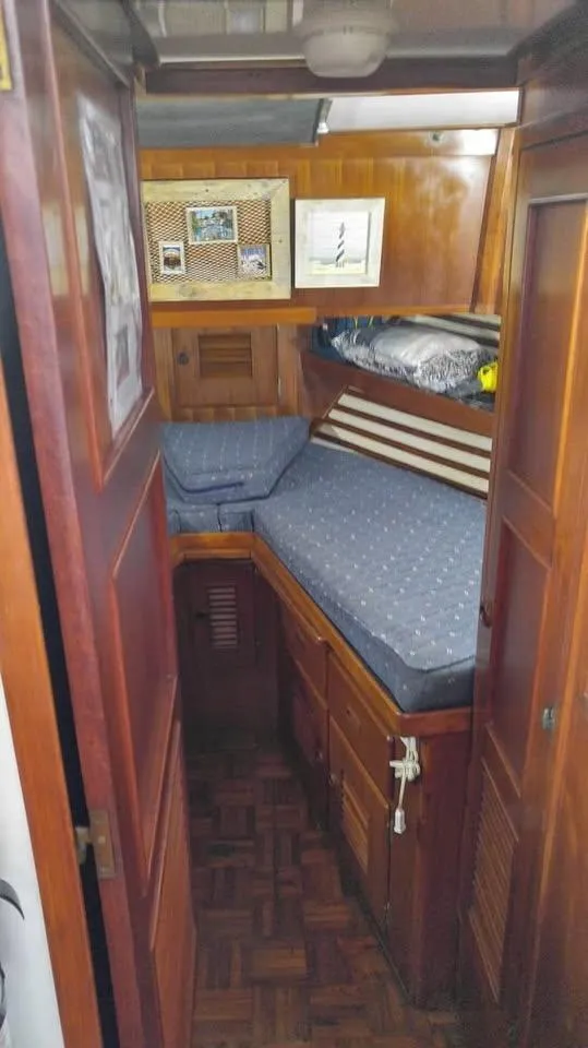 Slide: The Image of 1979 Universal Marine 41 cabin interior with wooden finish and cozy bedding. - 14