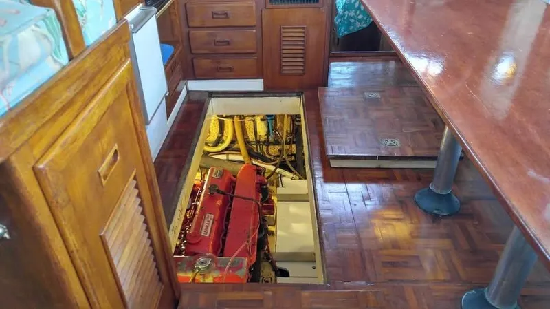 Slide: The Image of Engine room access in 1979 Universal Marine 41 boat, featuring wooden interior and visible engine. - 16