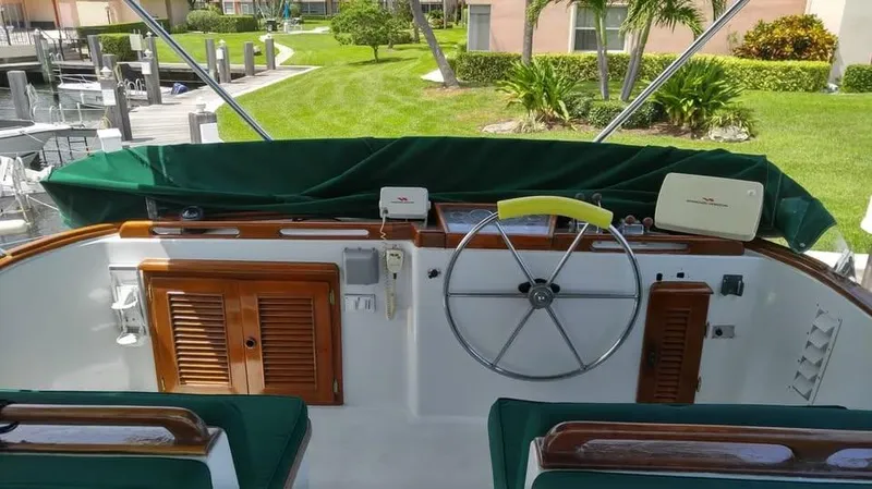 Slide: The Image of Cockpit of 1979 Universal Marine 41 yacht with wooden accents and green upholstery. - 3