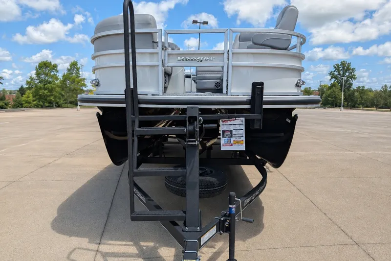 Slide: The Image of 2025 Ranger Reata 223FC pontoon boat on trailer in sunny parking lot. - 2