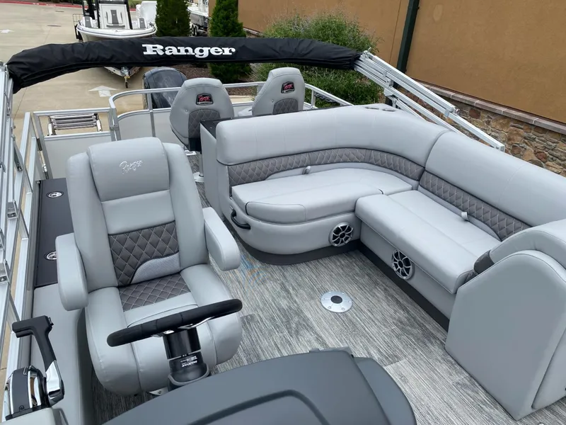 Slide: The Image of 2025 Ranger Reata 223FC boat interior with gray seating and steering console. - 3