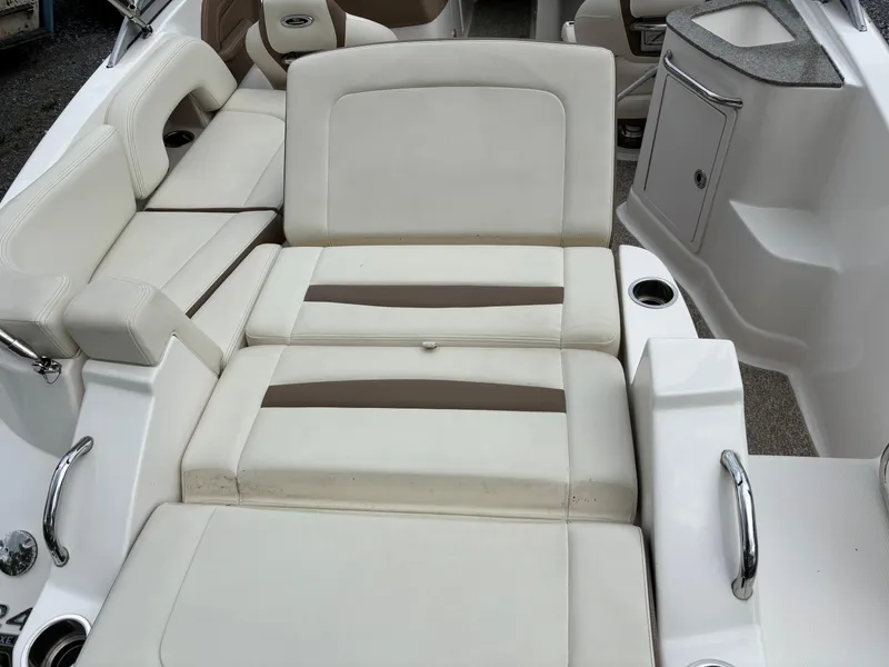 Slide: The Image of 2014 Chaparral 224 Sunesta boat interior with white cushioned seating and cup holders. - 17