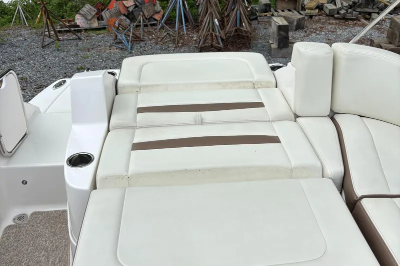 Slide: The Image of 2014 Chaparral 224 Sunesta boat interior with white cushioned seating and cup holders. - 19