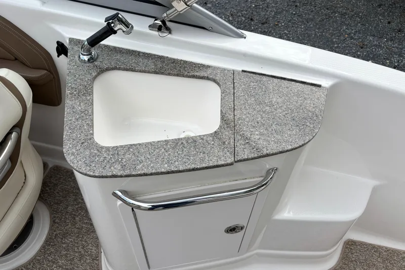 Slide: The Image of 2014 Chaparral 224 Sunesta boat sink with granite countertop and storage cabinet. - 25
