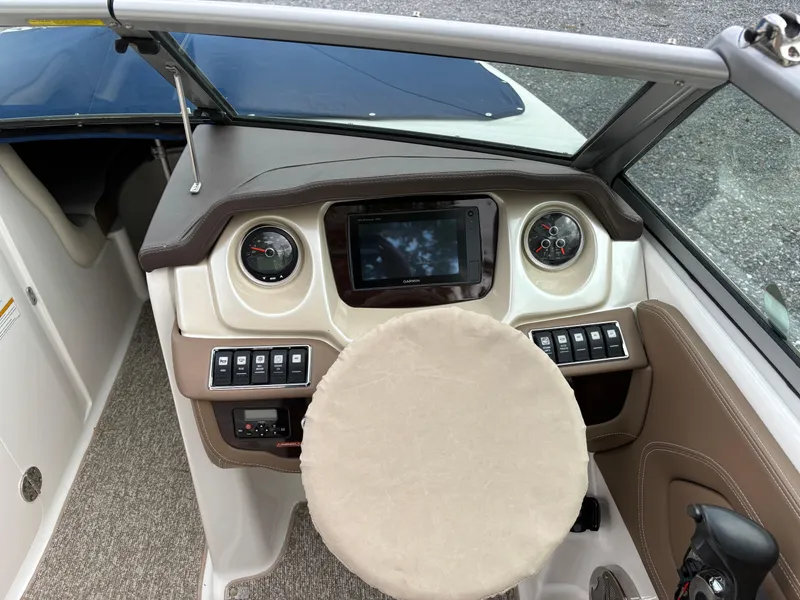 Slide: The Image of 2014 Chaparral 224 Sunesta boat dashboard with steering wheel and control panel. - 28