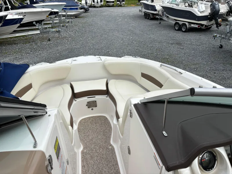 Slide: The Image of 2014 Chaparral 224 Sunesta boat interior with white seating, parked among other boats. - 37