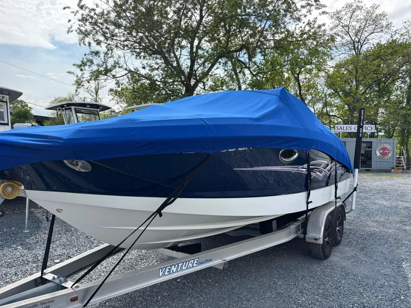 Slide: The Image of 2014 Chaparral 224 Sunesta boat on trailer, covered with blue tarp, parked outdoors. - 4