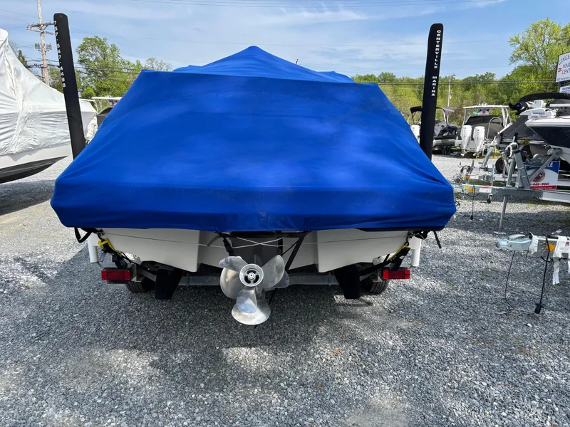 Slide: The Image of 2014 Chaparral 224 Sunesta boat with blue cover, parked on gravel. - 5