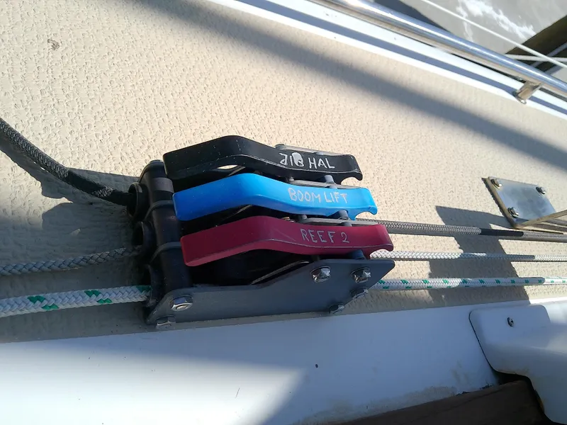Slide: The Image of Com-Pac 27/3 sailboat control lines and clutches, 2017 model, featuring jib halyard, boom lift, and reef. - 15
