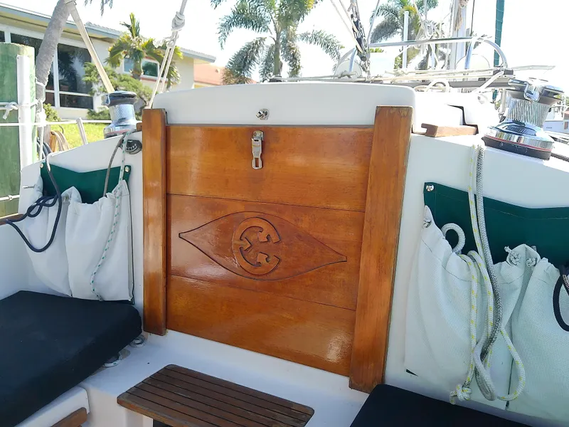 Slide: The Image of 2017 Com-Pac 27/3 sailboat cockpit with wooden hatch, cushions, and nautical ropes. - 28