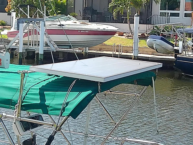 Slide: The Image of Sailboat with solar panel, Com-Pac 27/3, 2017 model, docked near other boats. - 7