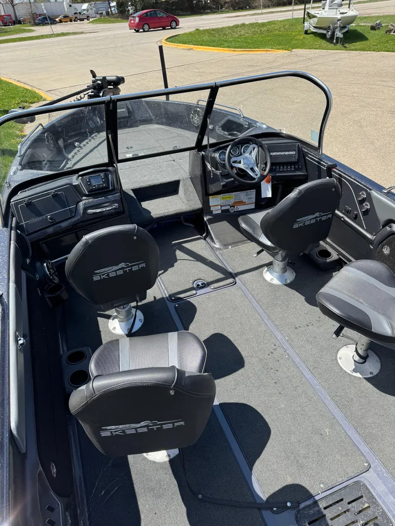 Slide: The Image of 2022 Skeeter Solera 205 boat interior with seating and steering wheel, parked outdoors. - 11