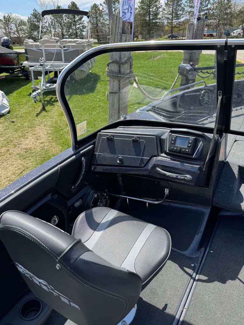 Slide: The Image of 2022 Skeeter Solera 205 boat interior with steering console and seat, displayed outdoors. - 17