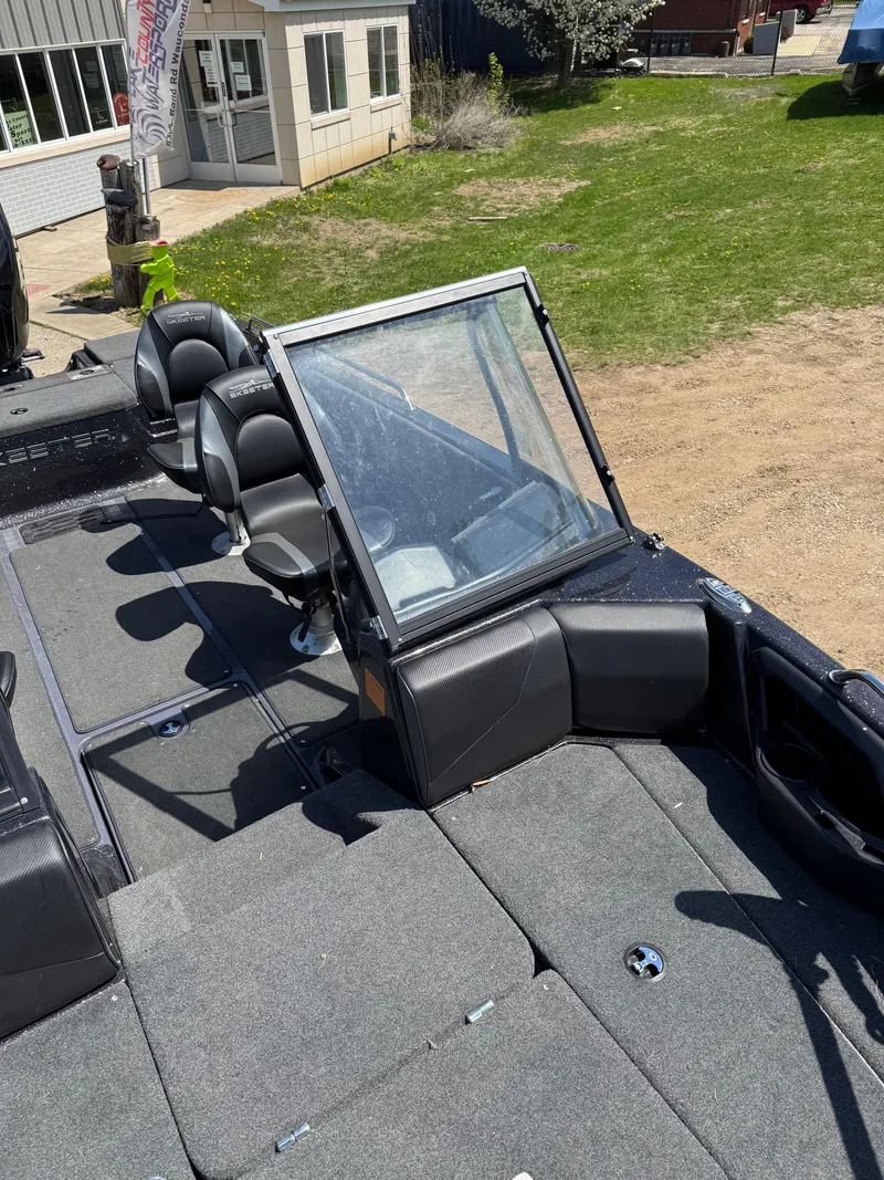 Slide: The Image of 2022 Skeeter Solera 205 boat with seating and windshield, parked on grass near a building. - 20