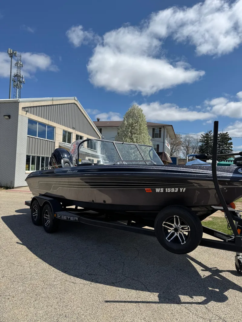 Slide: The Image of 2022 Skeeter Solera 205 boat on trailer, parked outdoors under a clear sky. - 27