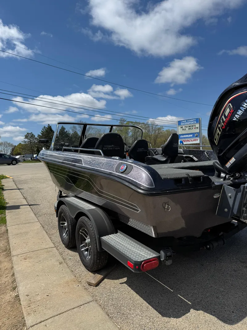 Slide: The Image of 2022 Skeeter Solera 205 boat on trailer, parked outdoors under a partly cloudy sky. - 5