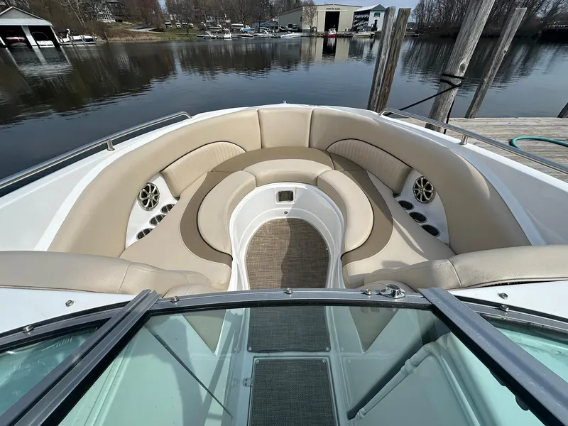 Slide: The Image of 2014 Cruisers Sport Series 278 Bow Rider with spacious seating, docked by a calm lake. - 13