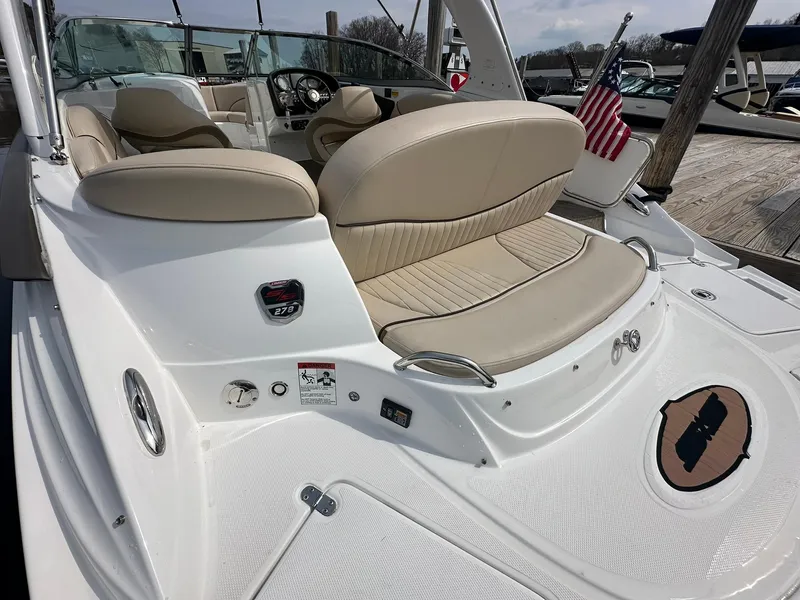 Slide: The Image of 2014 Cruisers Sport Series 278 Bow Rider with beige seating and American flag on dock. - 6