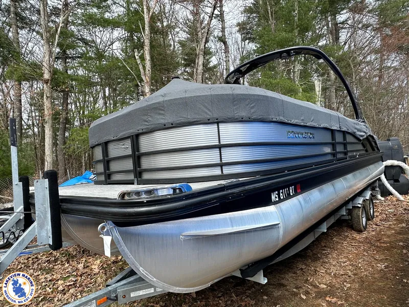 Slide: The Image of 2020 Bennington R 25 RSBA pontoon boat on trailer, covered, in wooded area. - 17