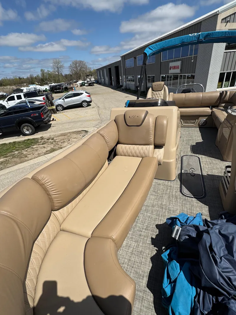 Slide: The Image of 2018 Harris Grand Mariner 230 pontoon boat with beige seating, parked outdoors. - 16