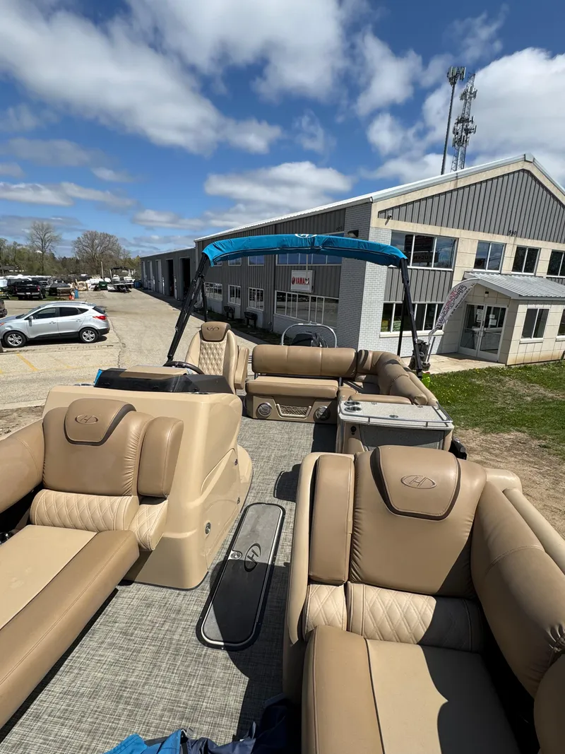 Slide: The Image of 2018 Harris Grand Mariner 230 pontoon boat with beige seating, parked near a building under a blue sky. - 17