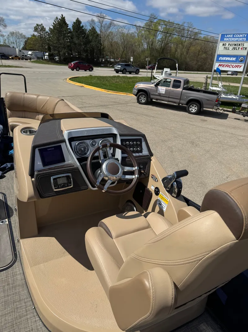 Slide: The Image of 2018 Harris Grand Mariner 230 boat interior with beige seating and modern dashboard controls. - 9