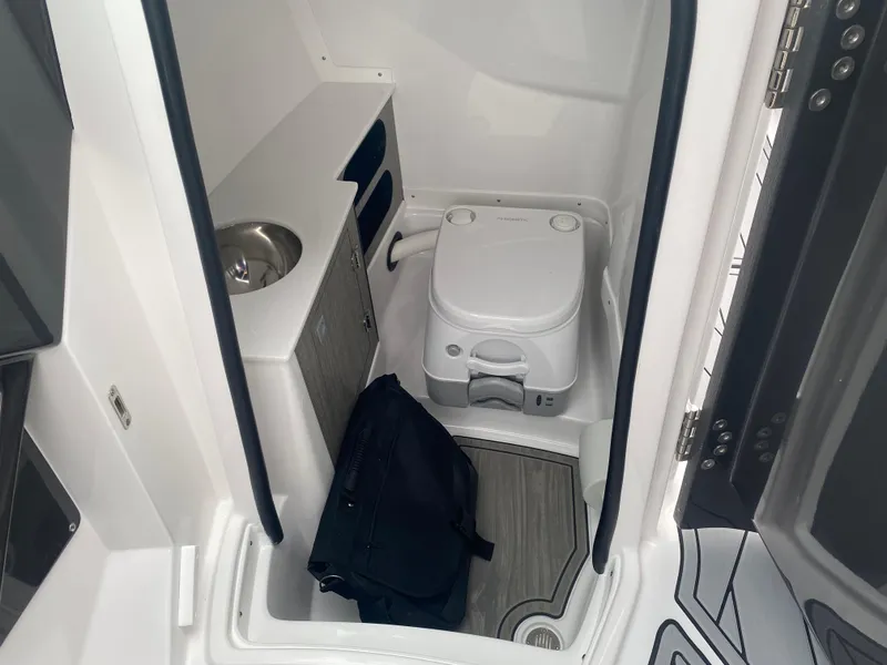 Slide: The Image of 2025 Monterey 258 Super Sport boat interior with compact toilet and sink. - 22