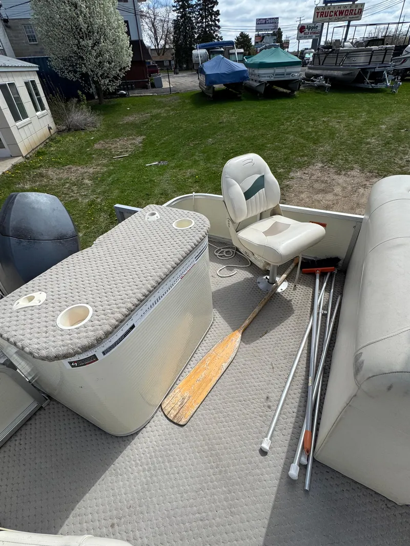 Slide: The Image of 2007 Bennington 2050 FSI boat interior with seating, storage, and paddles on deck. - 12