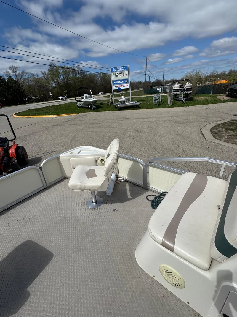 Slide: The Image of 2007 Bennington 2050 FSI boat interior with seating, parked outdoors under a partly cloudy sky. - 20