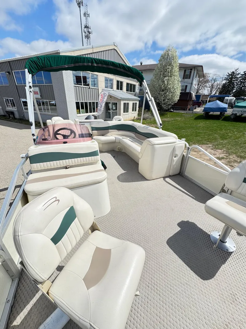 Slide: The Image of 2007 Bennington 2050 FSI pontoon boat with spacious seating and canopy, parked outdoors. - 22