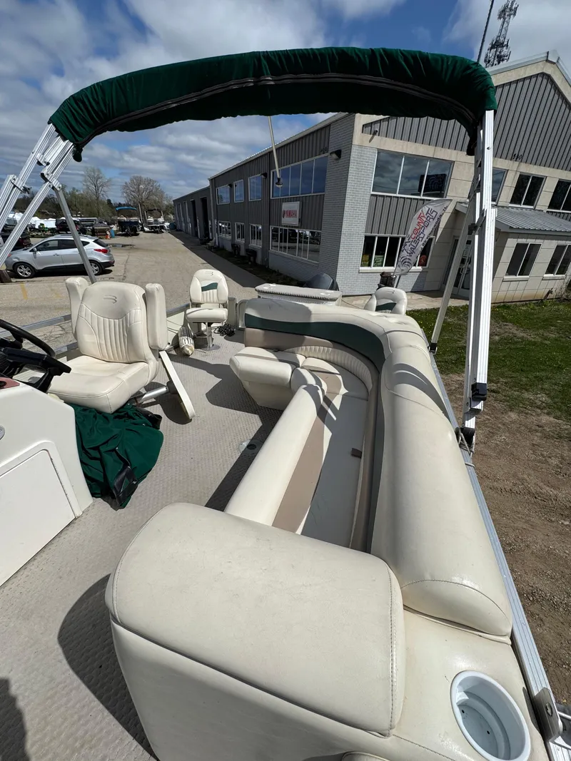 Slide: The Image of 2007 Bennington 2050 FSI pontoon boat with beige seating and green canopy. - 27