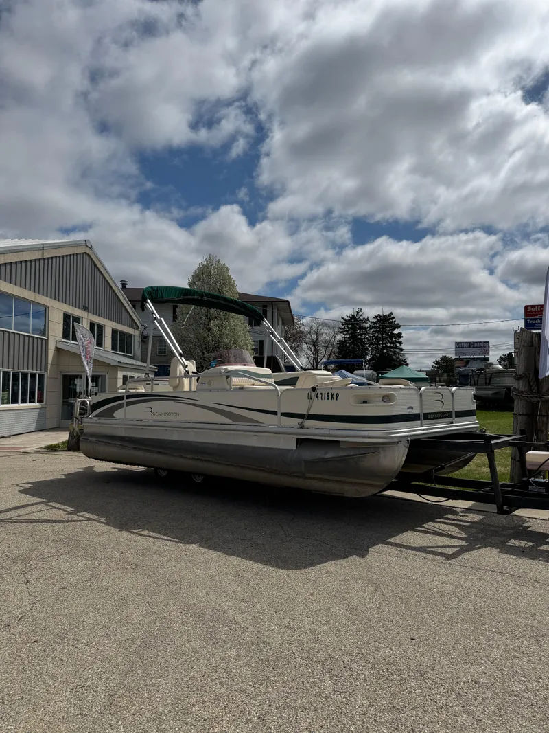 Slide: The Image of 2007 Bennington 2050 FSI pontoon boat parked outdoors under cloudy sky. - 3