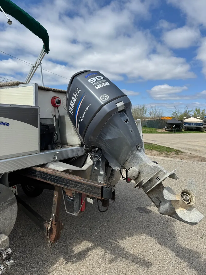 Slide: The Image of 2007 Bennington 2050 FSI boat with Yamaha 90 outboard motor, parked outdoors. - 32