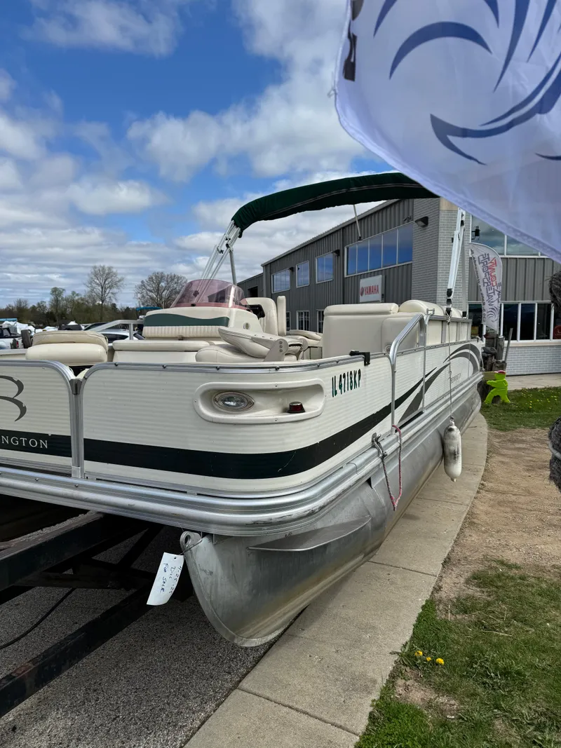 Slide: The Image of 2007 Bennington 2050 FSI pontoon boat parked near a building under a cloudy sky. - 7