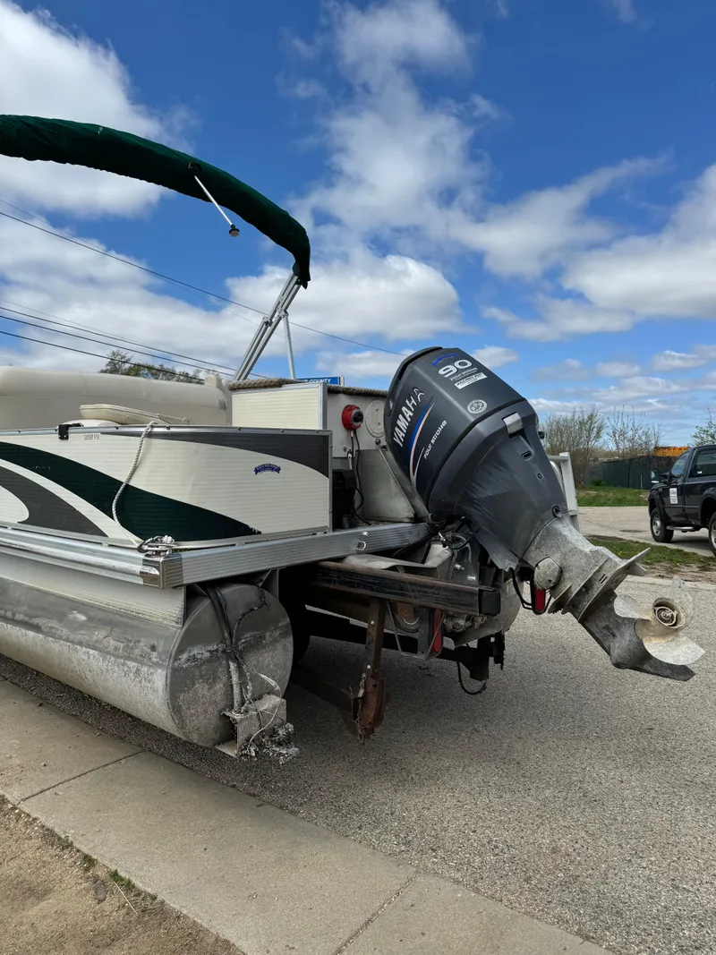 Slide: The Image of 2007 Bennington 2050 FSI pontoon boat with Yamaha outboard motor, parked on a street. - 8