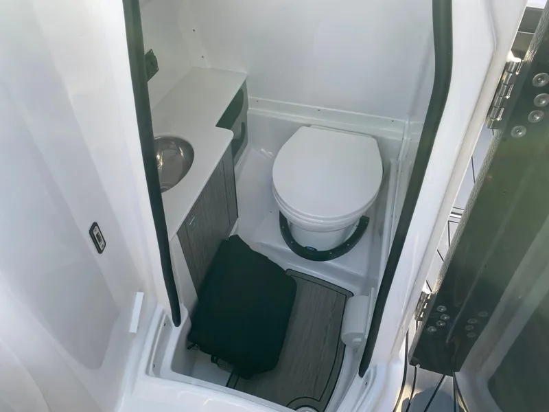 Slide: The Image of 2025 Monterey M6 boat bathroom with toilet, sink, and storage cabinet. - 15